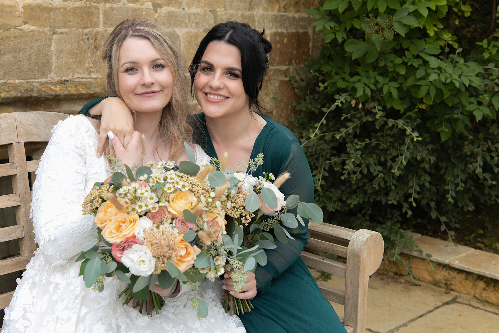 bride relaxing with her bridesmaid and wedding flowers